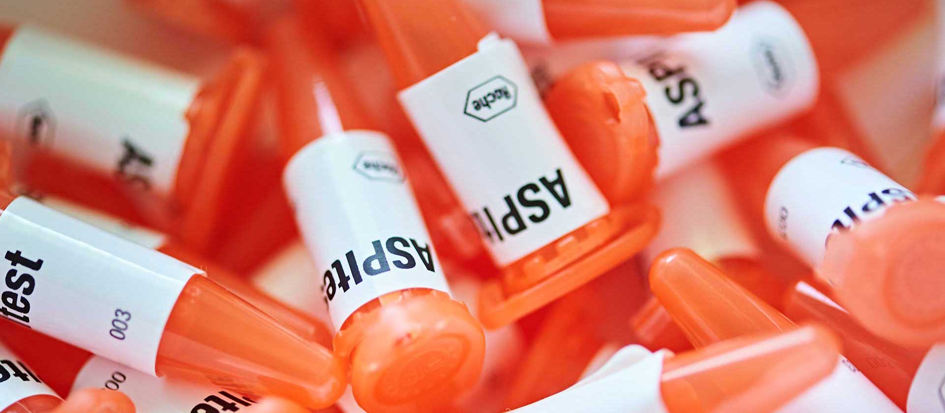 Mehrere orangefarbene Teströhrchen mit der Aufschrift 'ASPITest' im IHP-Labor.